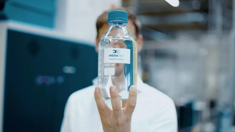 Geschäftsführer Dr.-Ing. Tim Böltken mit einer Flasche nachhaltigem e-Fuel. © INERATEC